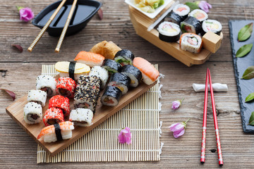 Wall Mural - A variety of sushi and green tea set on rustic wooden table.