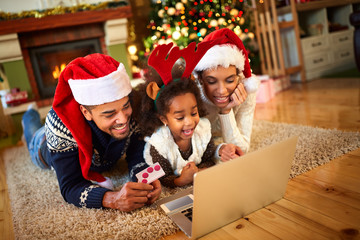 Smiling family lying on floor front of Christmas tree