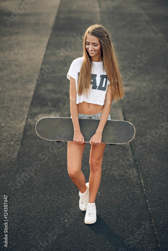 Beautiful Young And Sexy Smiling Teen Girl In A White T Shirt And Shorts Standing With Skateboard In Hands Stock Photo Adobe Stock