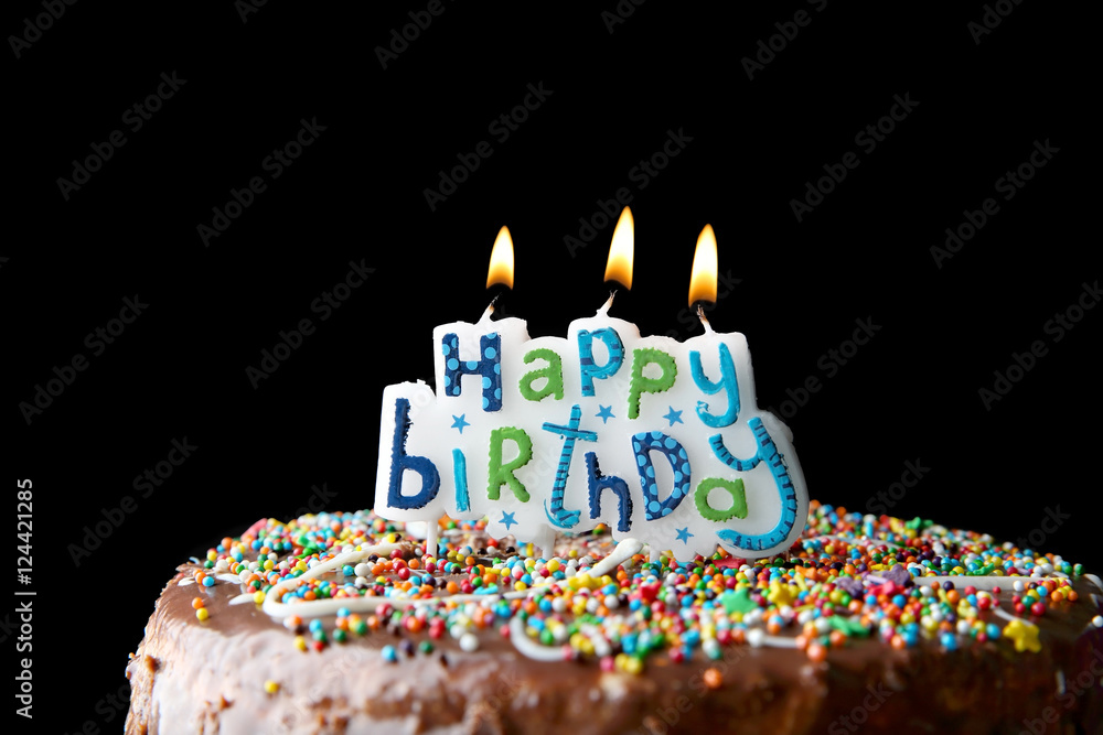 Birthday cake with greeting candles on dark background