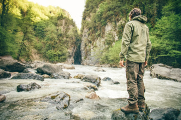 young man hiking outdoor lifestyle travel survival concept river and rocky mountains on background
