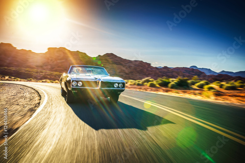 Fotografía driving fast through desert in vintage hot rod car