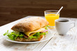 Chiabatta sandwich, cup of coffee and orange juice