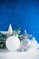 Wall Mural - silver and white xmas ornaments on blue bokeh background. merry christmas card. winter holiday theme