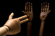About racsism. Two black hands up before the threat of a gun that is imitated by a white hand. Isolated on black background. Studio shot.