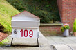 Bitte Einwerfen: Hübscher Briefkasten (Hausnummer 109) in Form eines Hauses auf einer Mauer eines privaten Wohnhauses