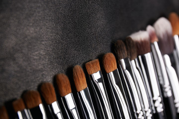 Wall Mural - Makeup brushes set on black leather background