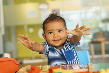 Happy baby playing with toy blocks.