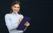 © Yuriy Shevtsov - Smiling business woman holding clipboard with pen.