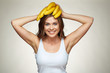 © Yuriy Shevtsov - Smiling woman holding banana on head.