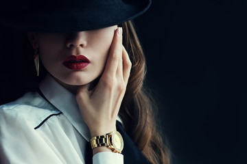 Indoor portrait of a young beautiful  fashionable woman wearing stylish accessories. Hidden eyes with hat. Female fashion, beauty and advertisement concept. Close up. Copy space for text