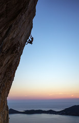 Wall Mural - Rock climber on overhanging cliff at sunset. Kalymnos Island, Greece.