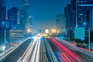 blurred traffic light trails on road at night in China.