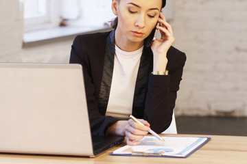 Business woman at office talking on phone about work