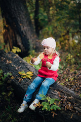 little girl in the red in the autumn forest, park