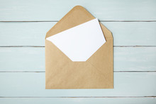 An Open Brown Envelope With Letter On A Blue Wooden Desk Top Background