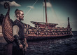 Viking warrior standing near Drakkar on seashore