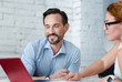 © zinkevych - Smiling bearded man looking at laptop