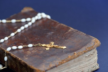 Wall Mural - Closeup of an old golden cross necklace on an ancient book (Holy Bible)