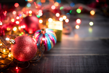 Christmas balls with Colorful Christmas lights on dark wooden ba