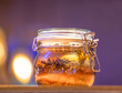 Decorative jar of herbs and spices with bokeh background.