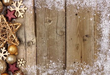 Wall Mural - Gold Christmas ornament side border with snow frame on a rustic wood background