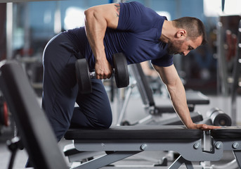 Man doing dumbbell row on bench