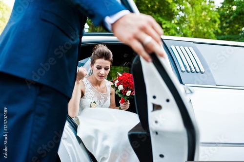 Groom open door of limousine and take hand to bride Tableau sur Toile