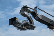 4K cinema production camera with crane in the blue sky. mass movie industrial.