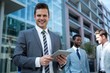 © WavebreakmediaMicro - Smiling businessman using digital tablet in the office building