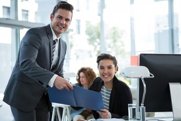 Wall Mural - Businesspeople discussing over document in office