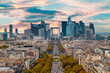 La Defense Financial District Paris France in autumn. Traffic on Champs-Elysees with orange and yellow trees aside. Modern vs. Old architecture. Sunset bright sky.
