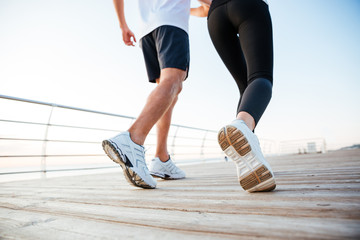 Cropped image of man and woman jogging outdoors