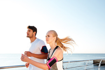 Canvas Print - Young sports athletes couple sprinting as part of healthy lifestyle