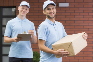 Wall Mural - Young couriers with package and clipboard