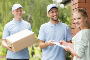 Wall Mural - Couriers and content woman signing a form