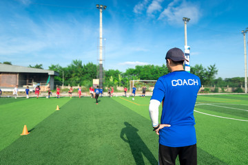 blurred image of coach is coaching children training in soccer t