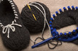 © Olvita - the process of knitting wool slippers gray yarn on a circular loom