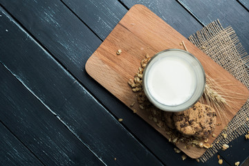 Glass of milk on table on blurred natural background