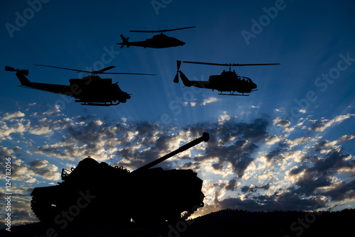 Zdjęcie XXL Wojskowy czołg i śmigłowce silhouetted przed świtem lub zmierzchu błękitne niebo