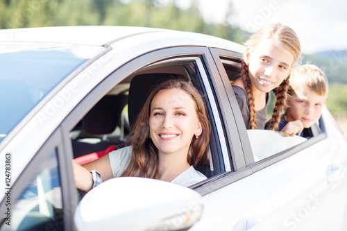 Fotografia, Obraz Happy young mom and her children sitting in a car