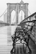 Brooklyn Bridge with no people on a rainy day with a bench in the foreground