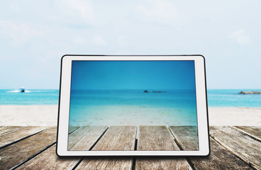 Wall Mural - Digital Tablet on Wooden Desk at the Tropical Beach 