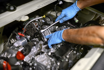 Hands of a mechanic working on a car engine