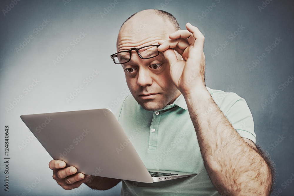 Closeup portrait surprised man working on laptop computer lookin
