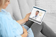 © Africa Studio - Pregnant woman video chatting with doctor on tablet. Professional medical online consultation concept.