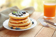 Stack of fresh pancakes with blueberry on natural blurred background