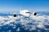 Fototapeta Niebo - Podróż samolotem, samolot latający w błękitne niebo nad chmurami