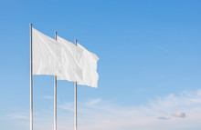 Three White Blank Flags Waving In The Wind Against Cloudy Sky. Perfect Mockup To Add Any Logo, Symbol Or Sign