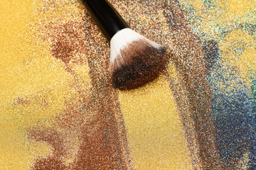 Cosmetics brush on golden background